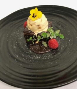 Chocolate brownie with ice cream and raspberries