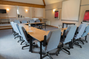 Conference meeting with desks and chairs with projector screen in Garden conference room at Guyers House Hotel