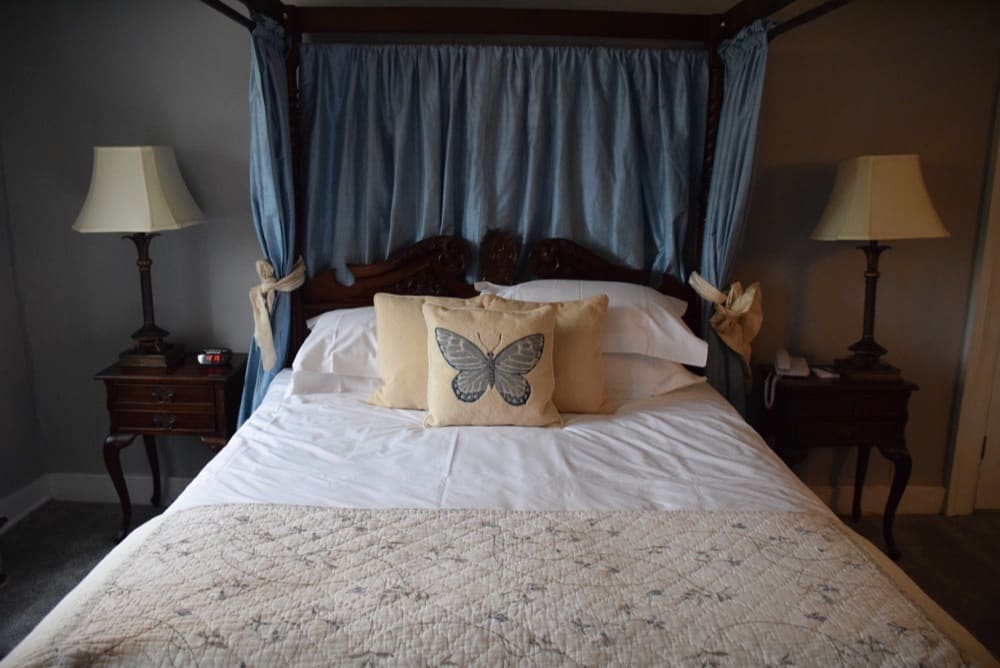 Double bedroom with four-poster bed and soft furnishings at Guyers House Hotel