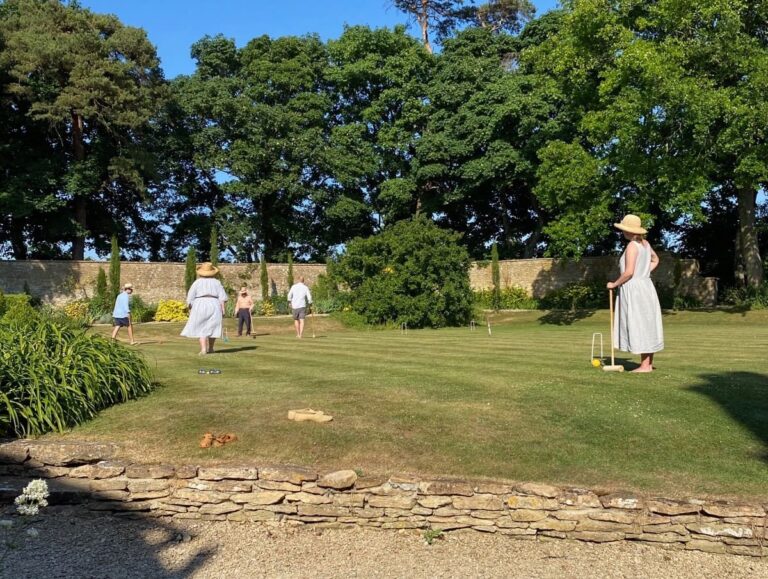 People playing croquet on the lawn in barefeet