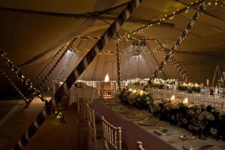 Inside wedding marquee with fair lights and fire pit